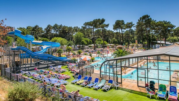 Un resort con parque acuático, zona de piscina y sillones de descanso.