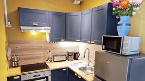 A compact kitchen with dark cabinets, a microwave, a toaster, a sink, and a refrigerator. - Apartment 7 - Cozy, near the train station and downtown, free parking (Châlons-en-Champagne)