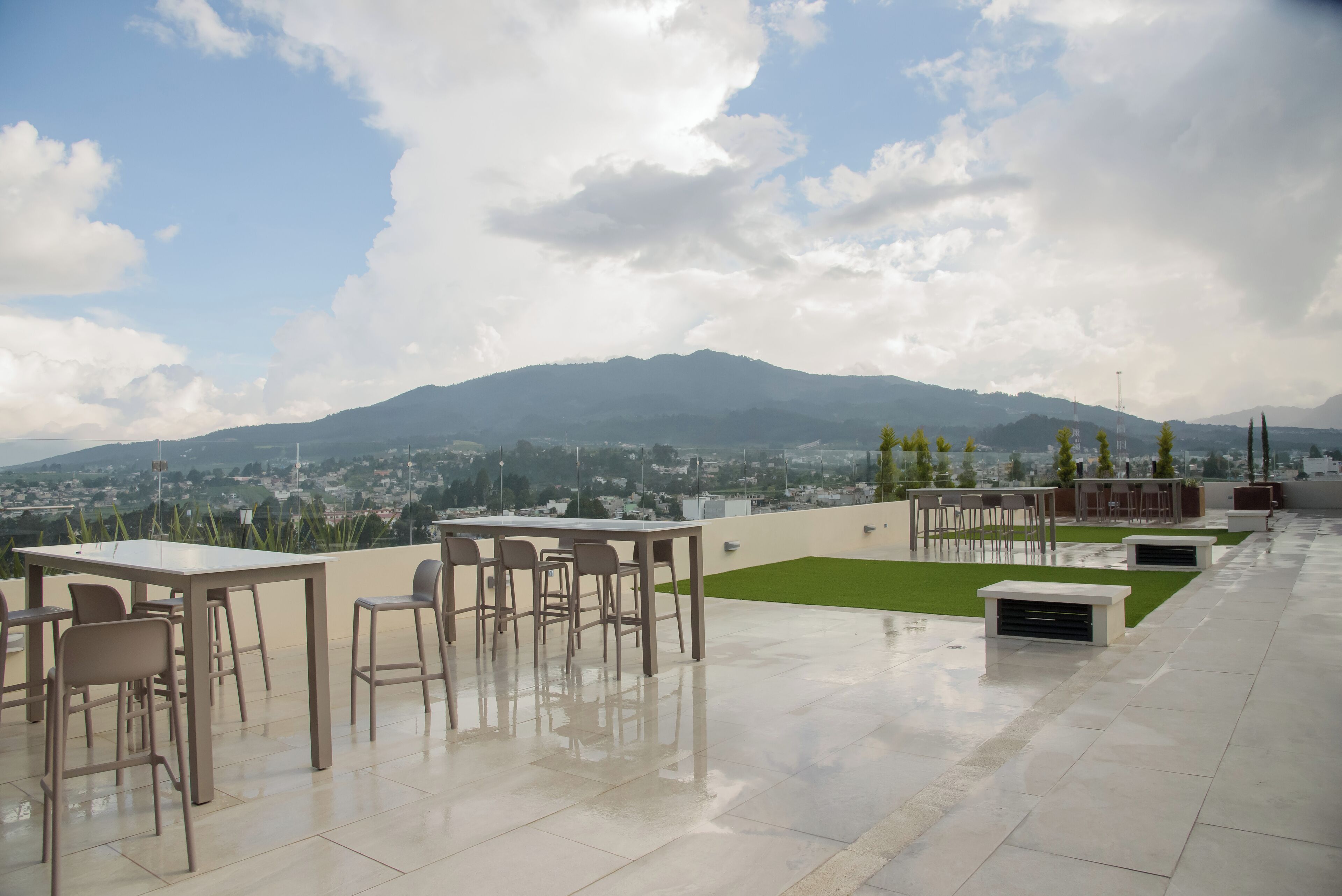 Una terrazza panoramica con zona pranzo, posti a sedere all'aperto e vista sulla città e sulle montagne.
