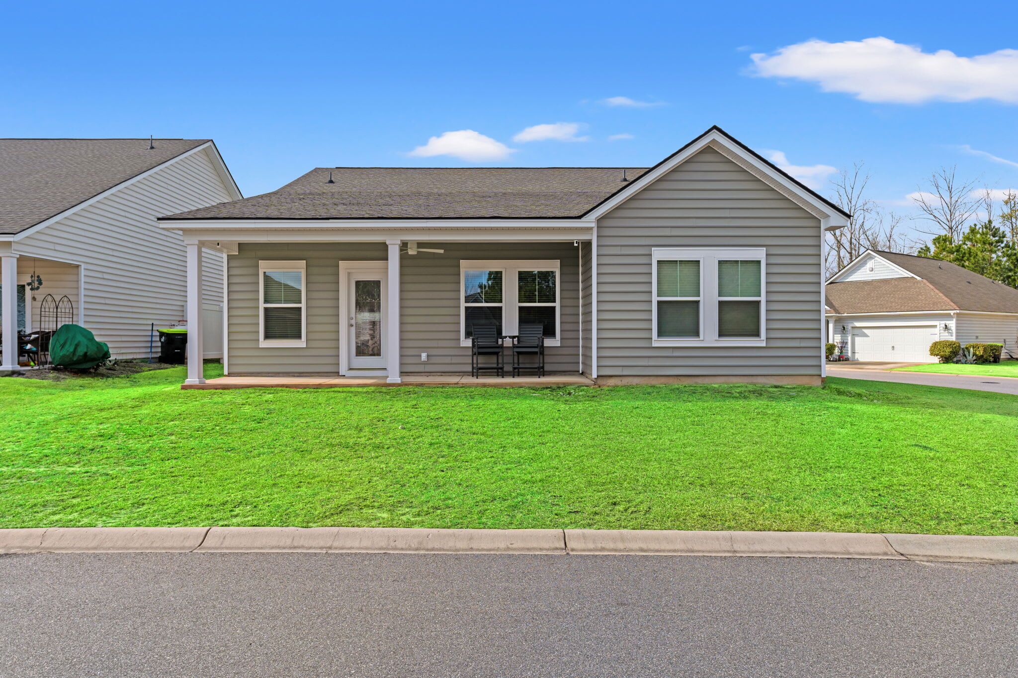 A single-story house with a covered porch, a front yard, and a driveway.