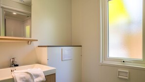A bathroom with a white sink, a towel, a mirror, a light switch, and a frosted window. - Palmyre - Privilège 2 - 4p (7) (Les Mathes)