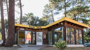 Una cabaña de madera con techo amarillo y puerta de cristal, identificada con la leyenda 'POINT INFO'.