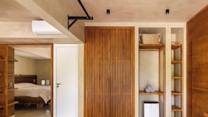 A bedroom with a bed, wooden wardrobe, and built-in shelving. - Casa com jacuzzi e rooftop by Wecare (Bertioga)