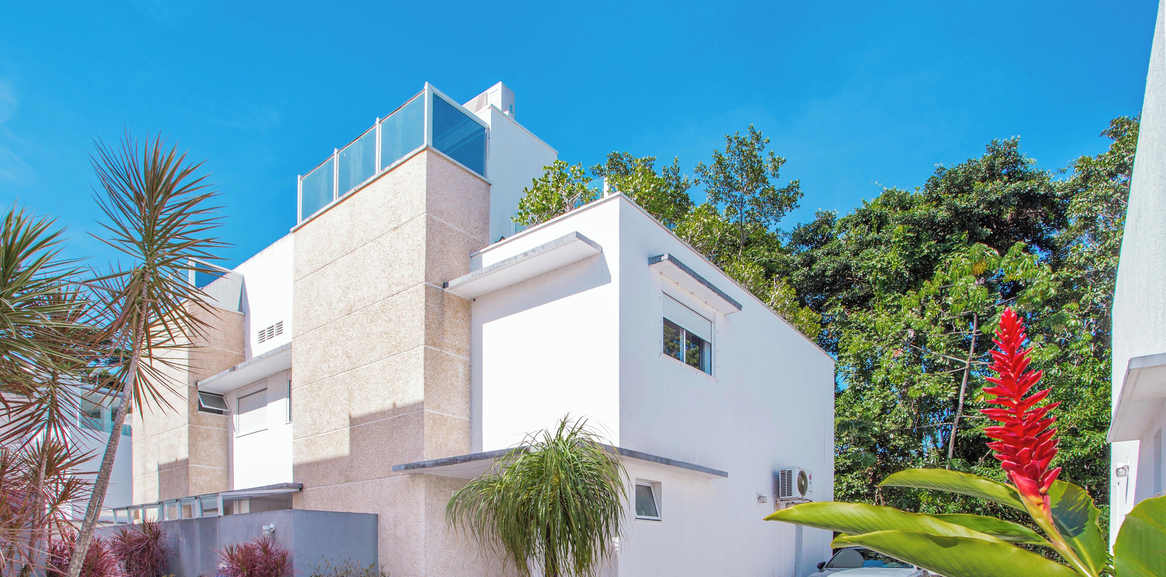 A modern building with a flat roof, large windows, and a balcony.