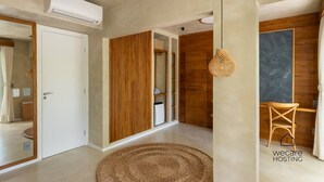 A modern interior with a wooden wardrobe, a woven rug, and a hanging light fixture. - Casa com jacuzzi e rooftop by Wecare (Bertioga)