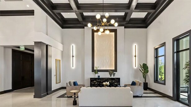 Eine moderne Lobby mit einer Rezeption, Sofas und einer Kronleuchter.