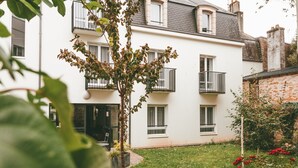 A two-story building with a white facade, multiple windows, and balconies. - Studio moderne à deux pas du centre-ville (Quimper)