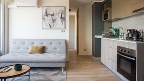 Una sala de estar moderna con un sofá gris, una mesa de centro y un cuadro en la pared.