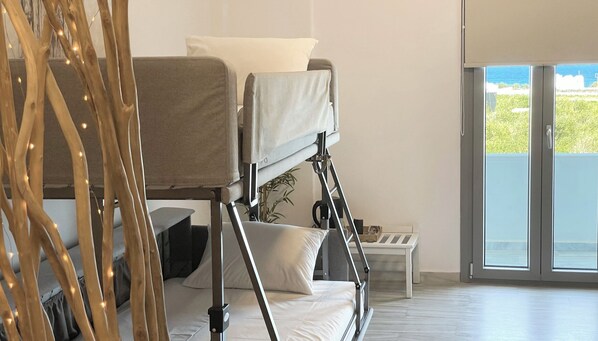 A bunk bed with a view of the outdoors through a sliding door. - DL Santorini (Santorini)