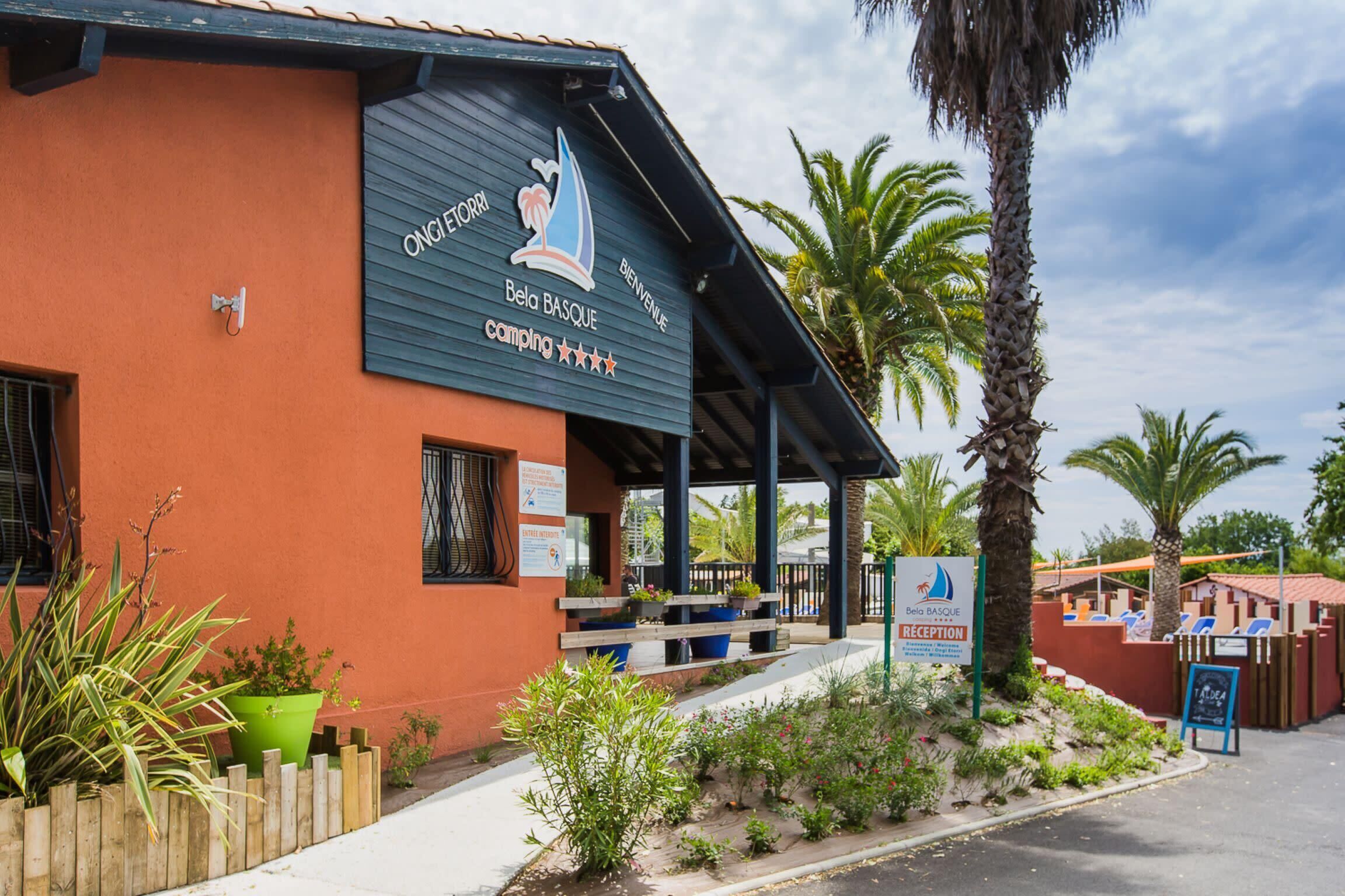 A building with a sign reading "Bela Basque camping" and a reception area.