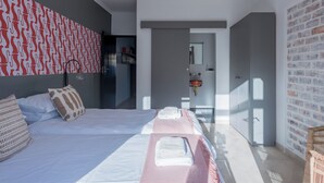 A modern bedroom with a large bed, a wardrobe, and a bathroom visible through an open door. - 2stay-Aparments (Cape Town)