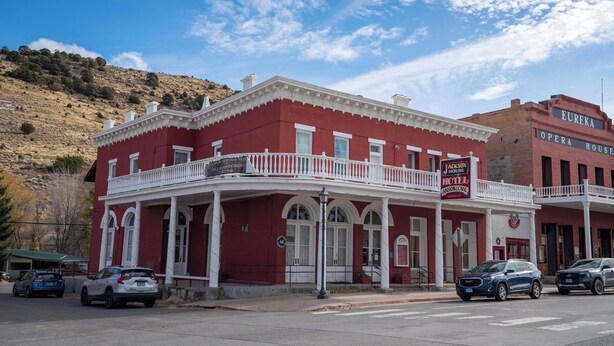 A red building with a white balcony and a sign for the Jackson Hotel.