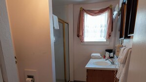 A bathroom with a toilet, sink, and shower.