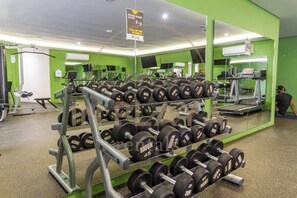 A gym with weightlifting equipment, treadmills, and exercise machines. - Luxury Studio w kitchen, Pool, Gym and Rooftop (Playa del Carmen)
