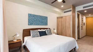 A bedroom with a bed, nightstands, a ceiling fan, a wall-mounted artwork, and a wooden wardrobe. - The Boat King Studio 200m to Beach w Rooftop Pool (Playa del Carmen)