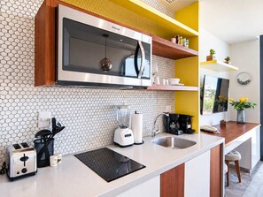 A modern kitchen with a built-in microwave, toaster, and coffee maker. - 1BR in Singular Joy, best location in town (Playa del Carmen)