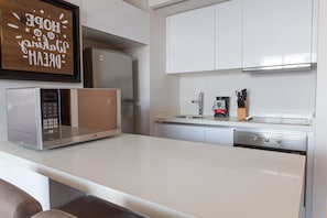 A modern kitchen with white cabinetry, a built-in microwave, a coffee maker, and a knife block. - Penthouse w Private Rooftop Pool, 150m to 5th Ave (Playa del Carmen)