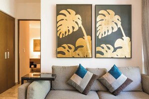 Ein modernes Wohnzimmer mit einer Couch, zwei Kissen und zwei gerahmten Kunstwerken an der Wand.