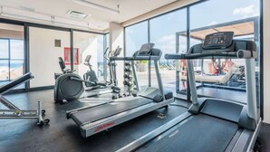 A gym with treadmills, elliptical machines, and weight equipment. - Beach 1BR w Balcony, Washer & Rooftop Pool (Playa del Carmen)