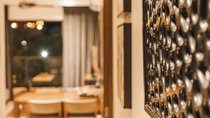 Ein Essbereich mit Tisch und Stühlen, ein Fenster mit Vorhängen und eine Wand mit Struktur.