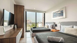 Een moderne hotelkamer met twee bedden, een flatscreen-tv, een groot raam met uitzicht over de stad en een schilderij aan de muur.