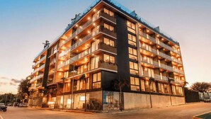 Een hotel met meerdere verdiepingen, balkons, grote ramen en een modern architectonisch ontwerp.