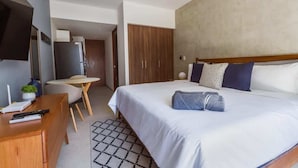 Une chambre d’hôtel équipée d’un lit, d’un bureau, d’une chaise, d’une télévision et d’une armoire.