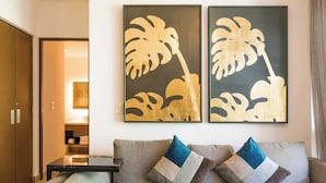 Een moderne woonkamer met een bank en twee abstracte schilderijen aan de muur.