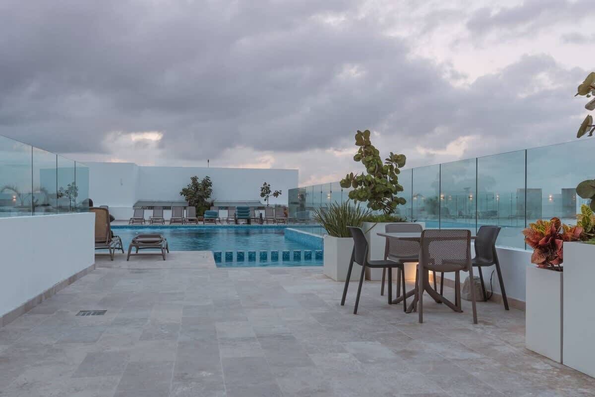 Uma área de piscina no terraço com espreguiçadeiras e um espaço para sentar.