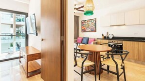 Una cocina moderna con comedor, armarios de madera y una obra de arte colorida en la pared.