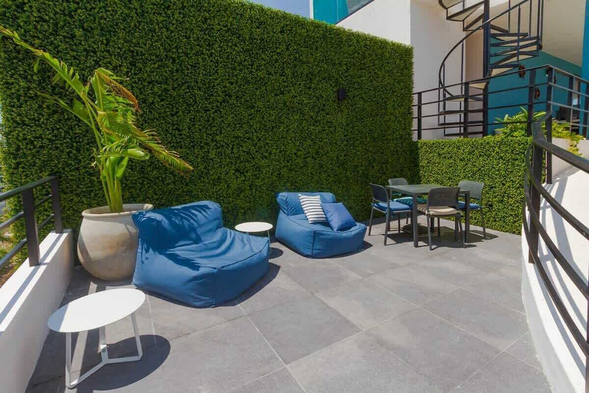 An outdoor seating area with blue bean bags, a small round table, and a potted plant.