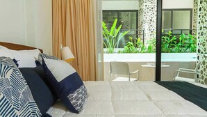 Ein Hotelzimmer mit einem großen Bett, Balkonblick und modernem Interieur.