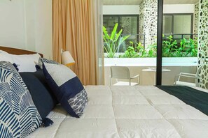 Ein Hotelzimmer mit einem großen Bett, Balkonblick und modernem Interieur.