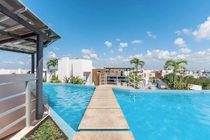 A swimming pool with a clear view of the cityscape in the background. - Studio w Rooftop Pool & Free Parking (Playa del Carmen)