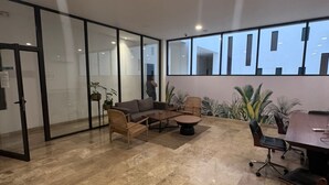 A spacious office with a large meeting table, comfortable seating, and large windows offering views of the outside. - Rooftop Pool and Private Hot Tub with Ocean Views (Playa del Carmen)