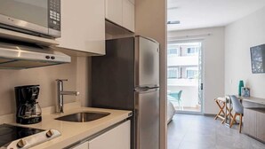 Eine moderne Küche mit einem Edelstahl-Kühlschrank, einem Einbauofen und einer Kaffeemaschine.
