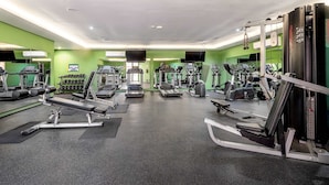 Ein Fitnessstudio mit Laufbändern, Crosstrainern und Krafttrainingsgeräten.