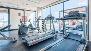 Een sportschool met loopbanden, elliptische trainers en gewichten.