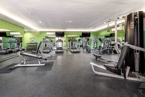 A gym with treadmills, elliptical machines, and weight machines. - Stylish Condo Steps to 5th Ave w Pools & Gym (Playa del Carmen)