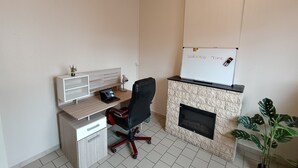 Een moderne kantoorruimte met een bureau, stoel, whiteboard en open haard.