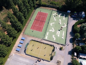 An aerial view of a sports complex with multiple tennis courts, a smaller field, and surrounding greenery. - CampingSpa - Confort 2 TV - 5p (2) (La Couarde-sur-Mer)