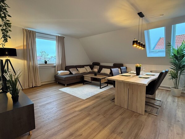 Eine moderne Loftswohnung mit Wohnbereich, Essplatz und einem großen Fenster für natürliches Licht.