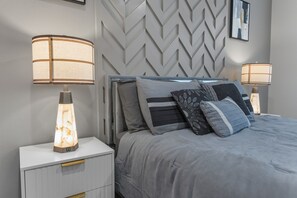 Ein modernes Schlafzimmer mit einem Bett, zwei Nachttischen und zwei Wandleuchten.