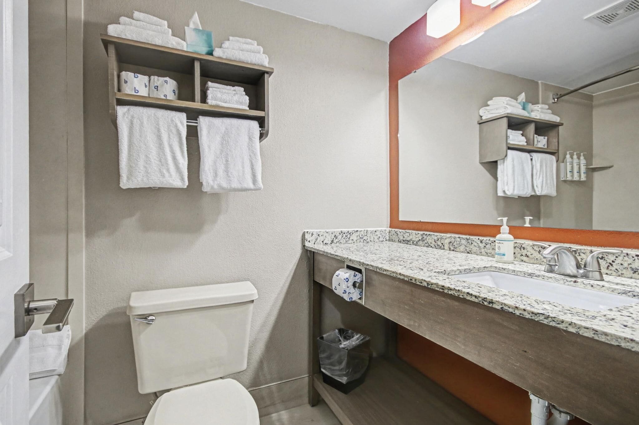 Un baño con inodoro, lavamanos y toallero.