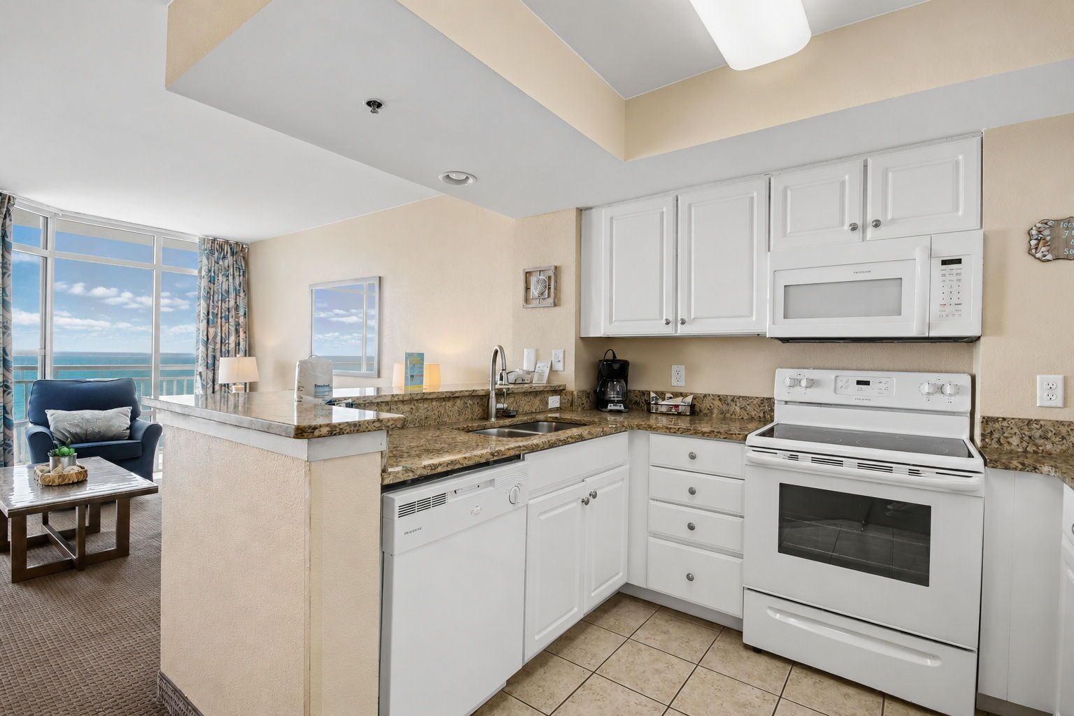 A kitchen with white cabinets, a microwave, a stove, and a coffee maker.