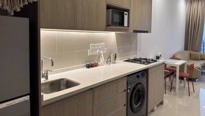 Une cuisine moderne équipée d’un four à micro-ondes encastré, d’un lave-vaisselle et d’une cuisinière à gaz.