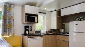 Una cucina compatta con forno a microonde, tostapane e frigorifero.