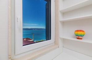 A window with a view of the sea and a hot air balloon on a shelf. - Luxury Penthouse, Sea View Terrace 100m2, Jacuzzi, BBQ, 8 Guests, Private floor (Mimice)