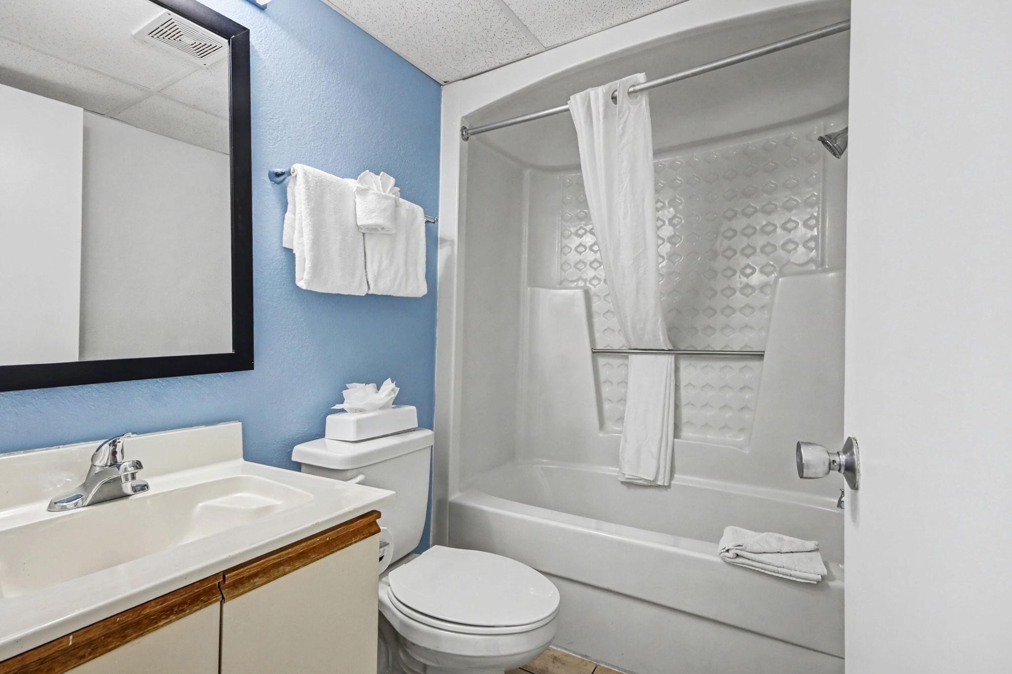 A bathroom with a sink, toilet, and bathtub.