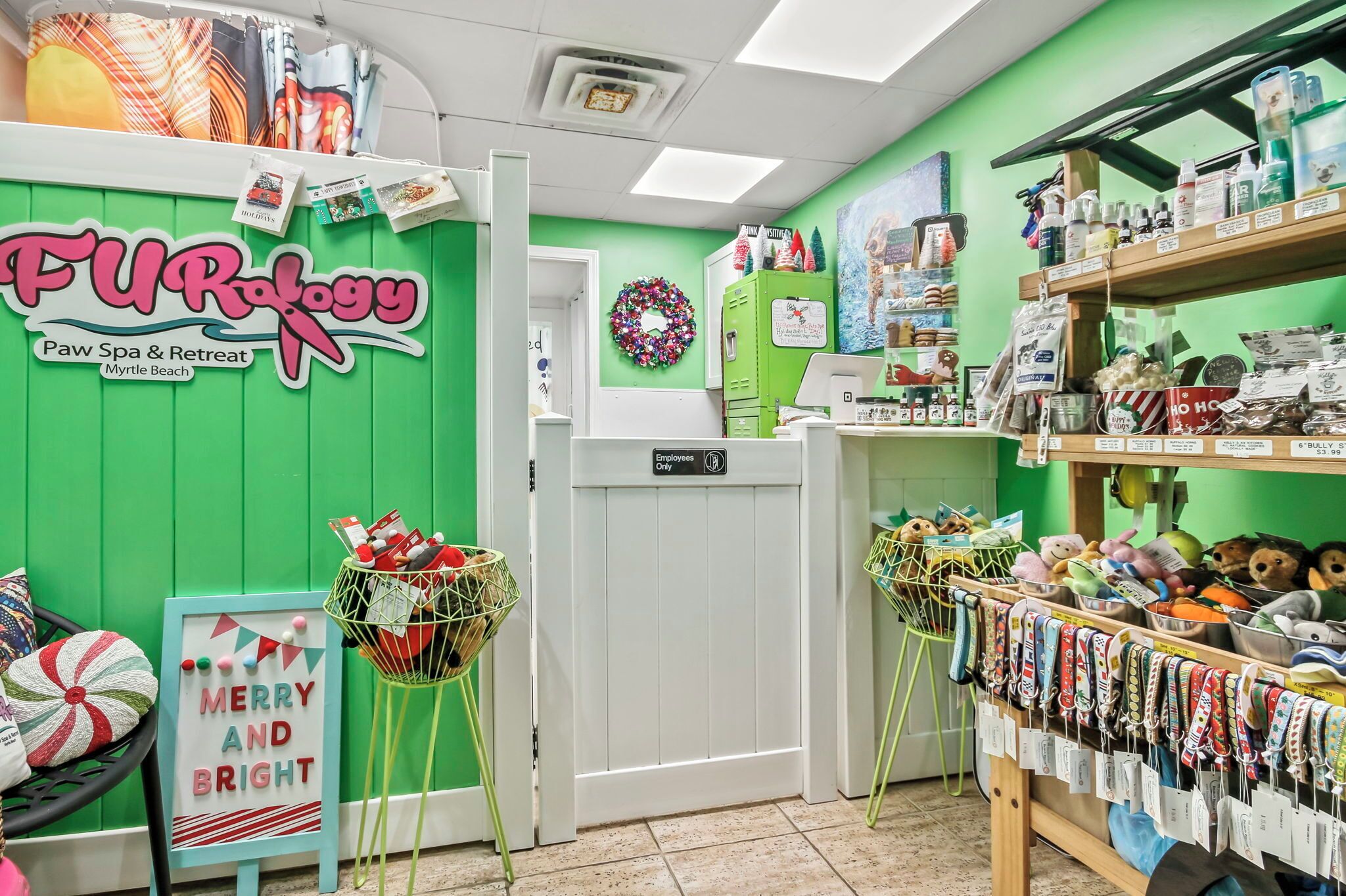 Un spa y refugio acogedor para mascotas, con una pared verde, un letrero que dice 'Merry and Bright' y varios productos para animales en estantes.